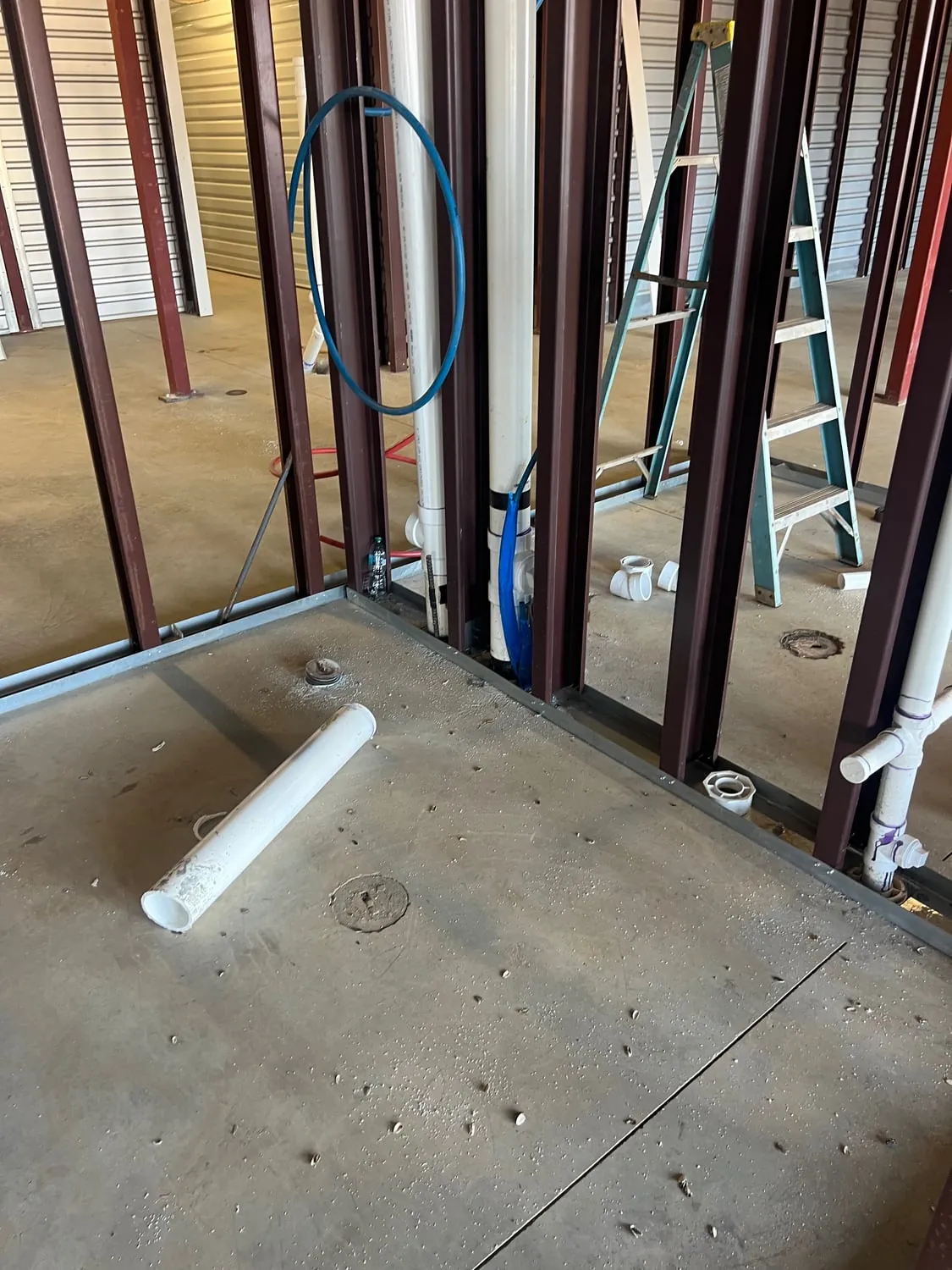 Drain stubs and supply lines roughed in between steel wall framing
