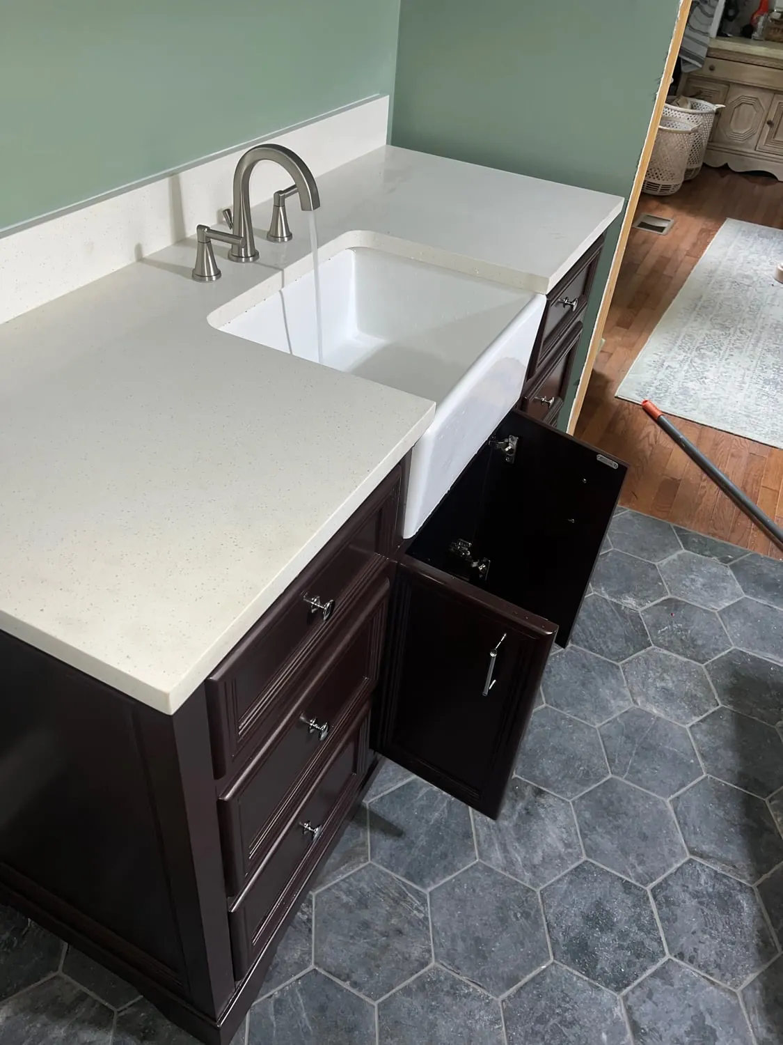 Farmhouse-style vanity sink with a brushed nickel faucet running