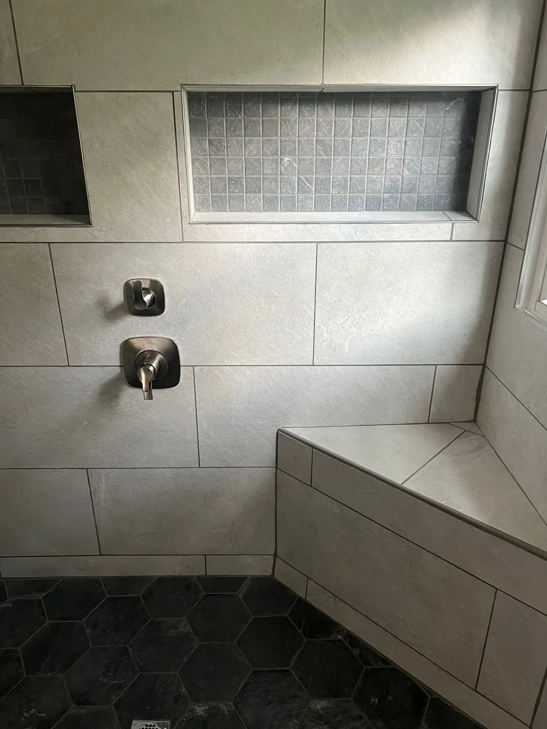 Shower valve and trim above a tiled shower bench